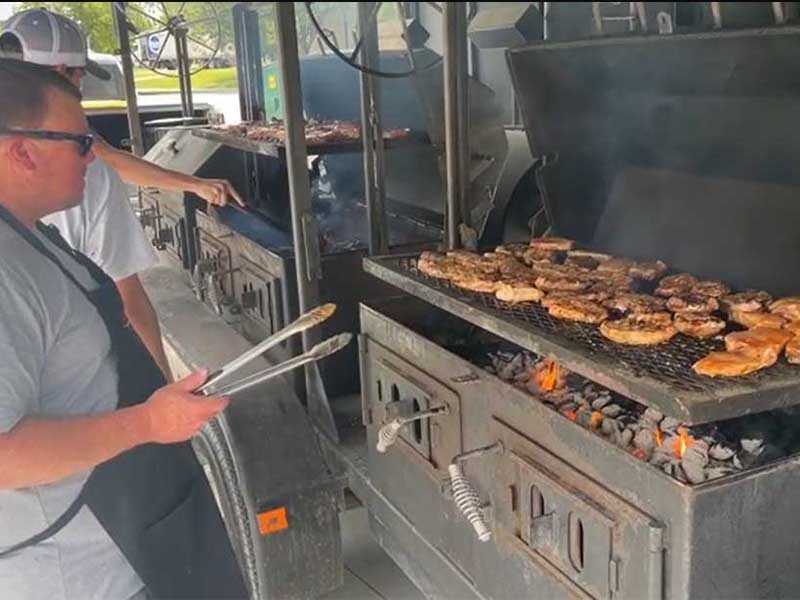 Volunteers grilling food on a smoker for attendees at the ImpactLife Blood Drive in Ottumwa, Iowa at Southeast Iowa Sports Center